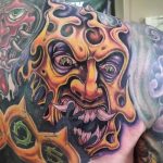 Fiery demon mask shoulder tattoo.